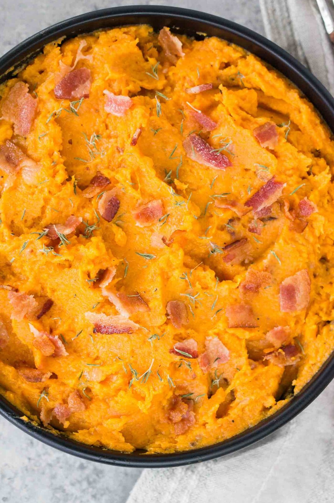 close up image of mashed sweet potatoes in a black bowl