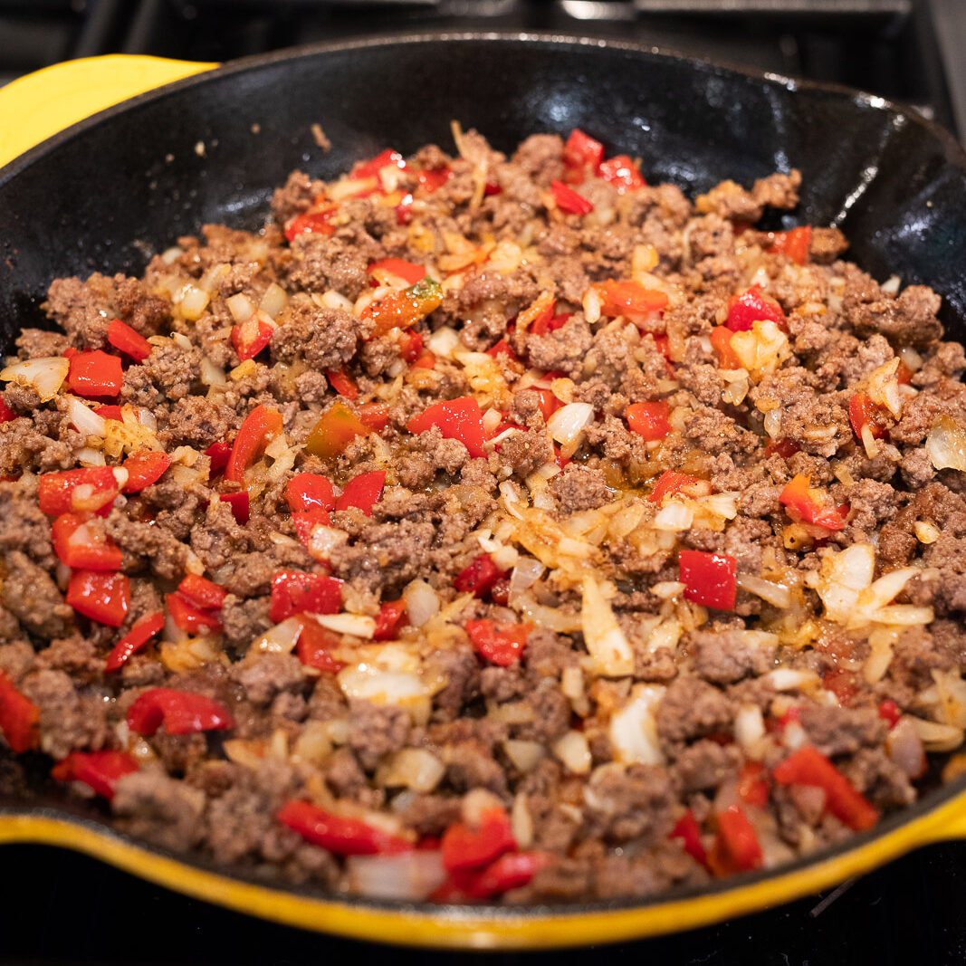 cooking peppers and ground beef in a skillet
