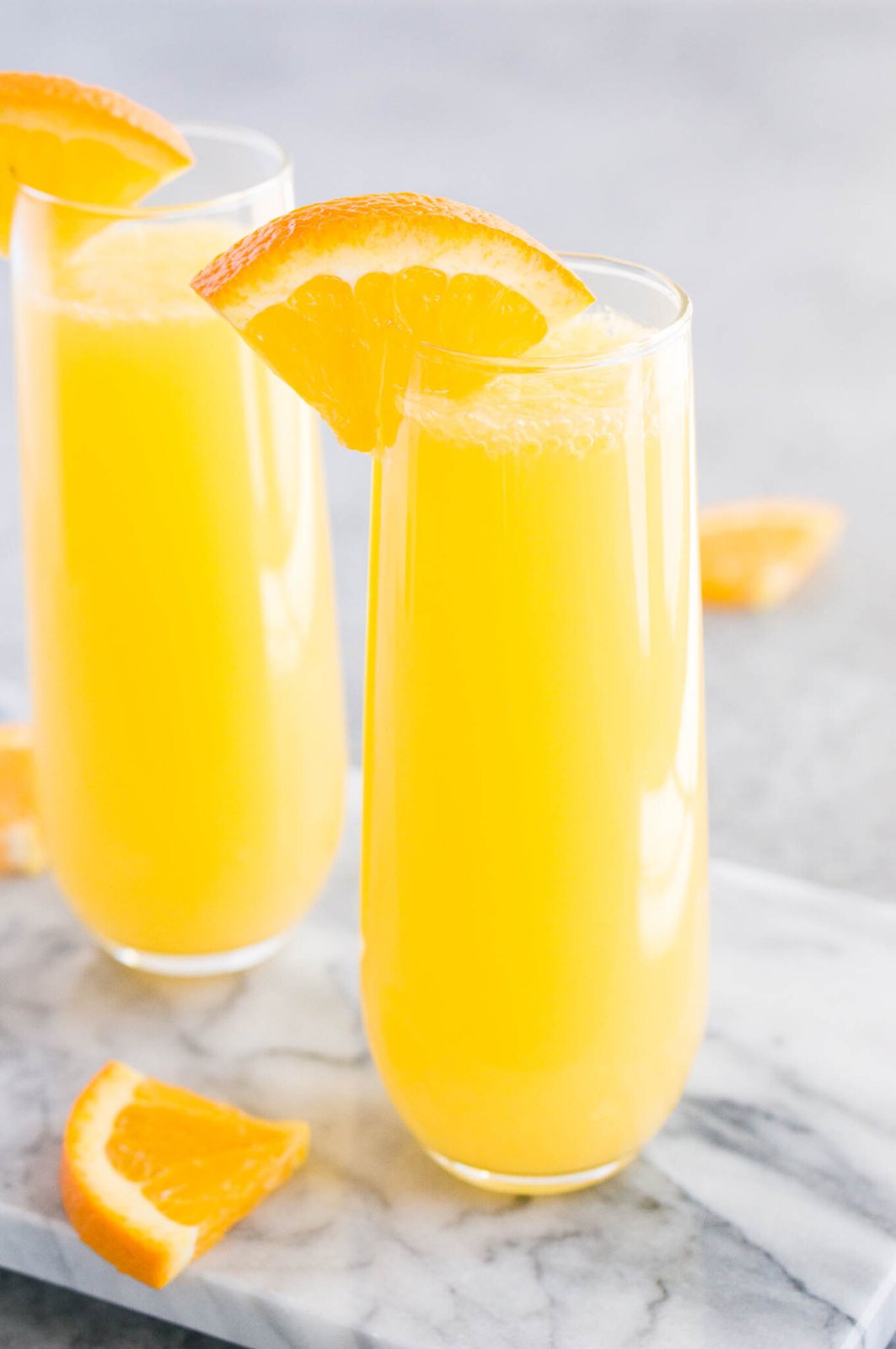 Mimosa cocktail serve in glasses and garnished with orange slices