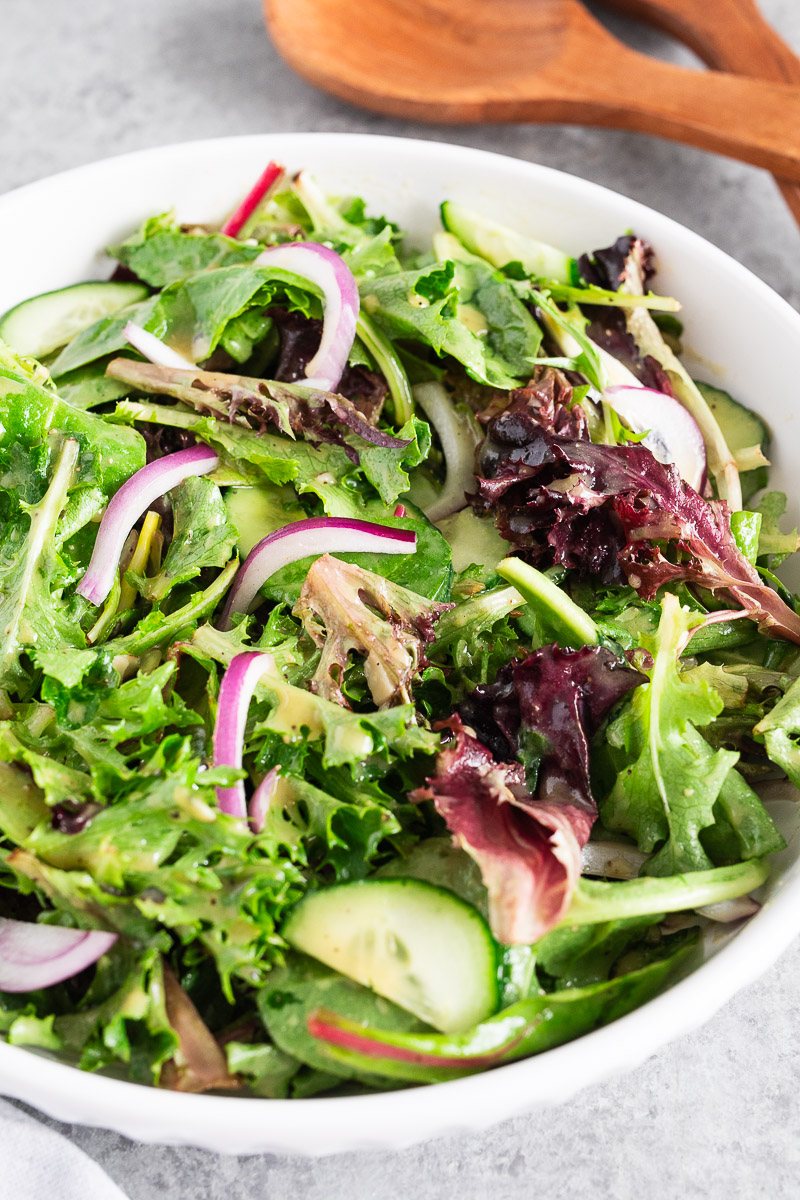 serving mixed green salad in a bowl
