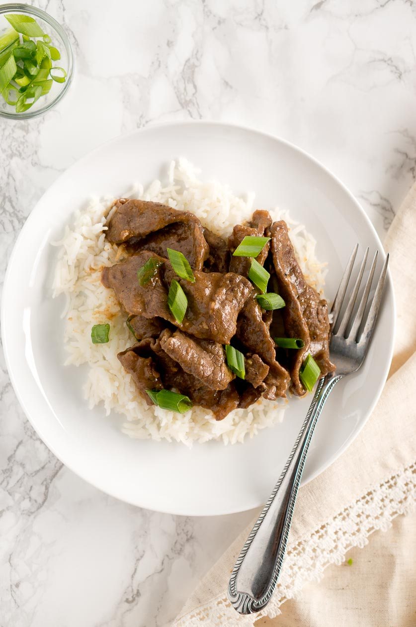 Easy Mongolian Beef served on a white plate with a fork