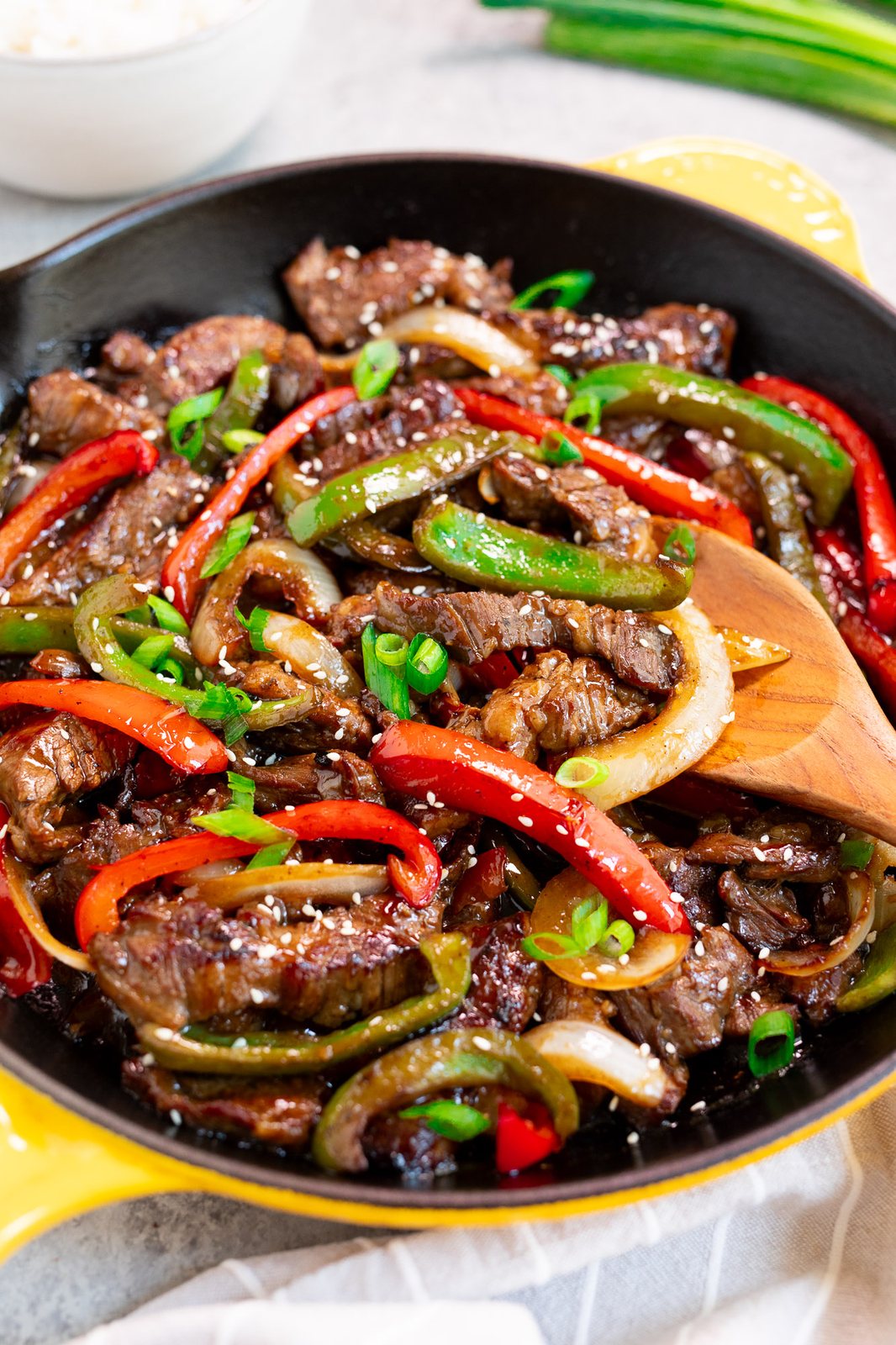 flank steak peppers and onions stir fry in a skillet