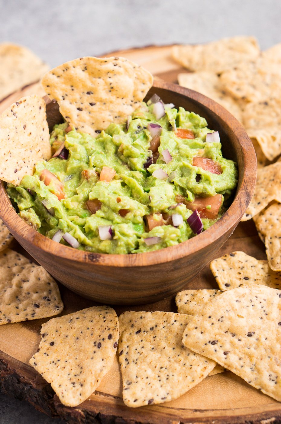 avocado guacamole in a wooden bowl with chips