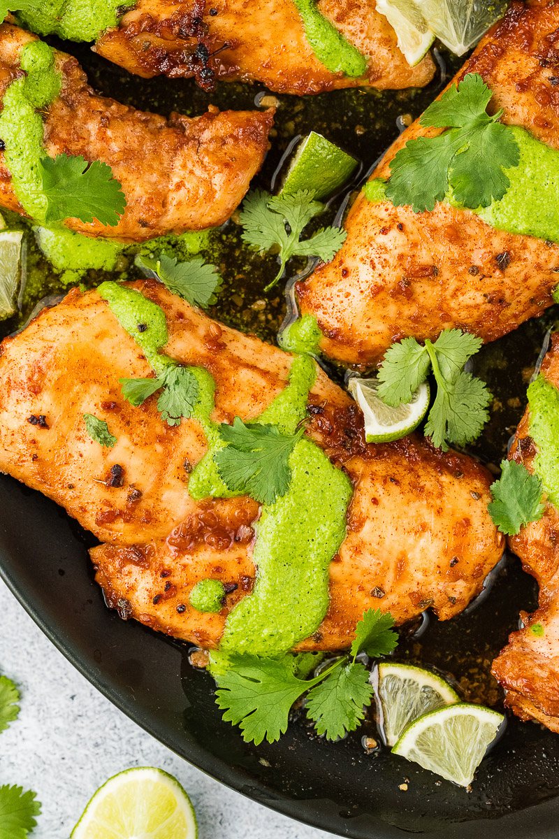 peruvian chicken with green sauce aji verde and limes served on a black platter