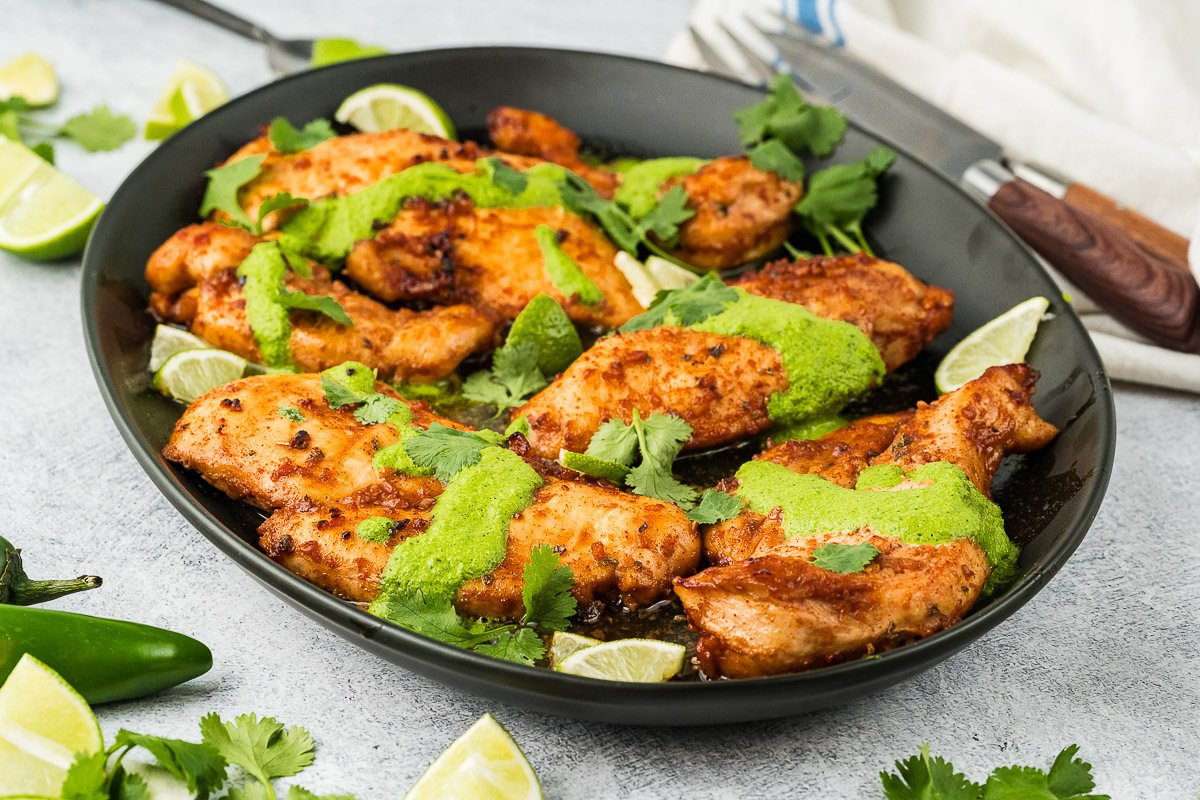 peruvian chicken breasts with green sauce served on a platter