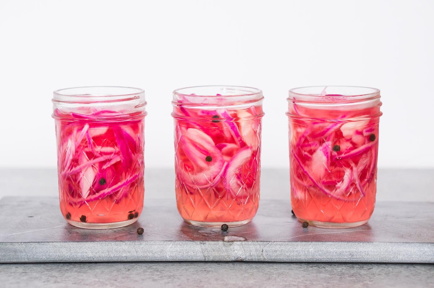 three jars with pickled red onions