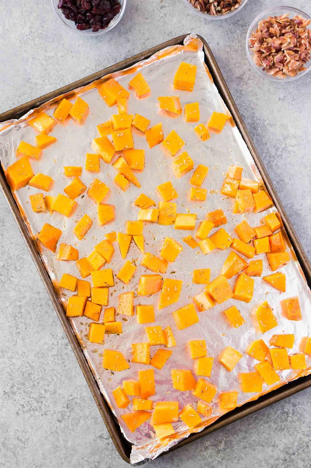 roasting butternut squash cubes on a baking sheet
