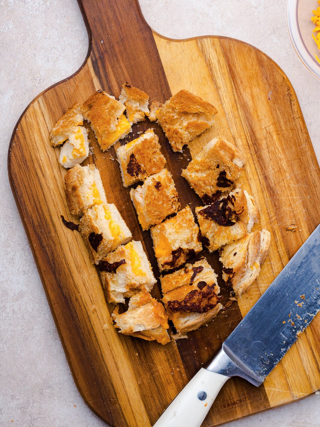 cut grilled cheese croutons on a cutting board