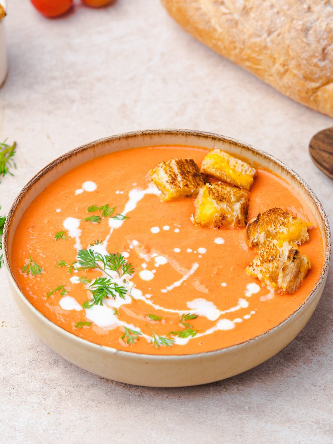 roasted tomato soup in a bowl with grilled cheese croutons
