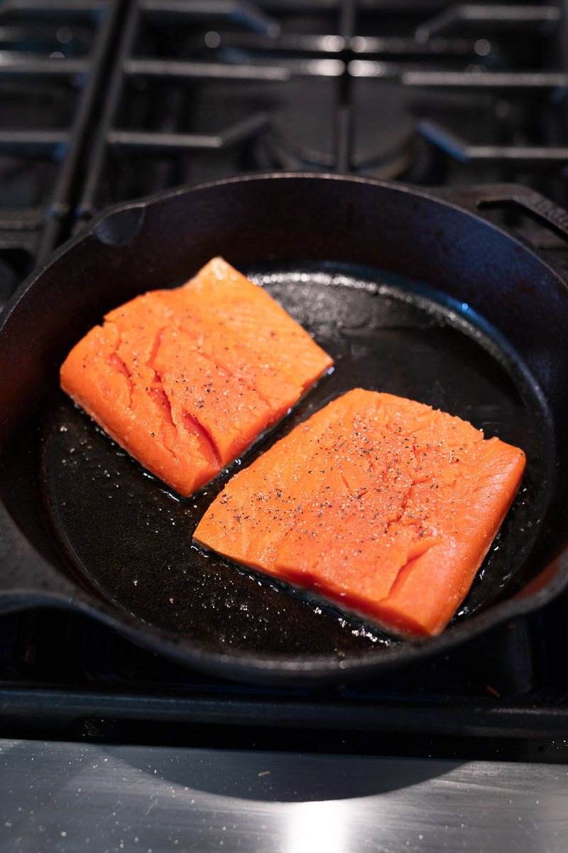 pan searing salmon in a skillet