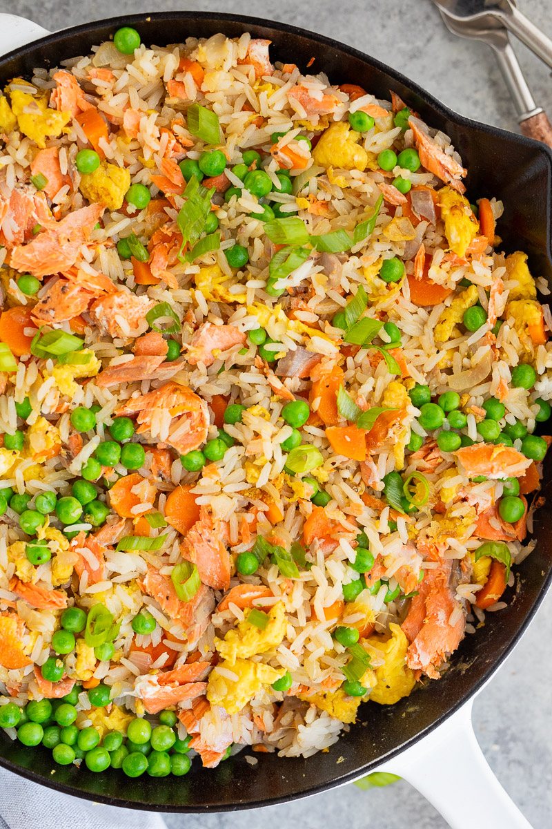 rice vegetables and salmon cooked in a skillet