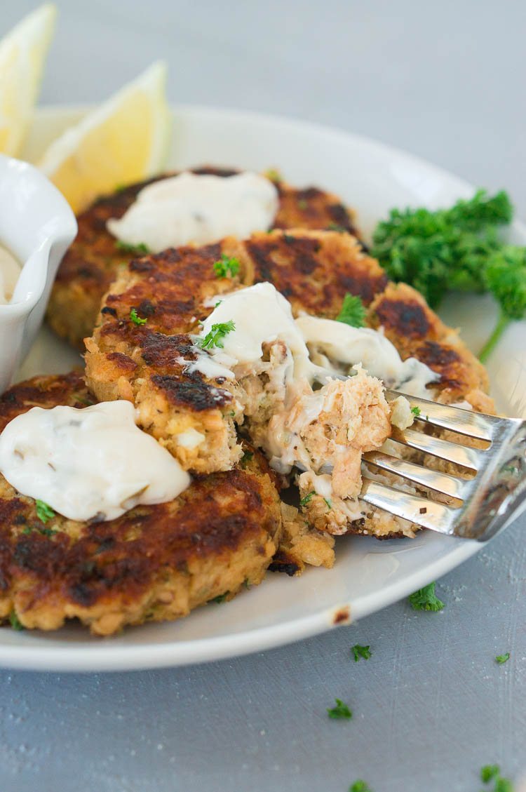 taking a bite with a fork from salmon fish cakes