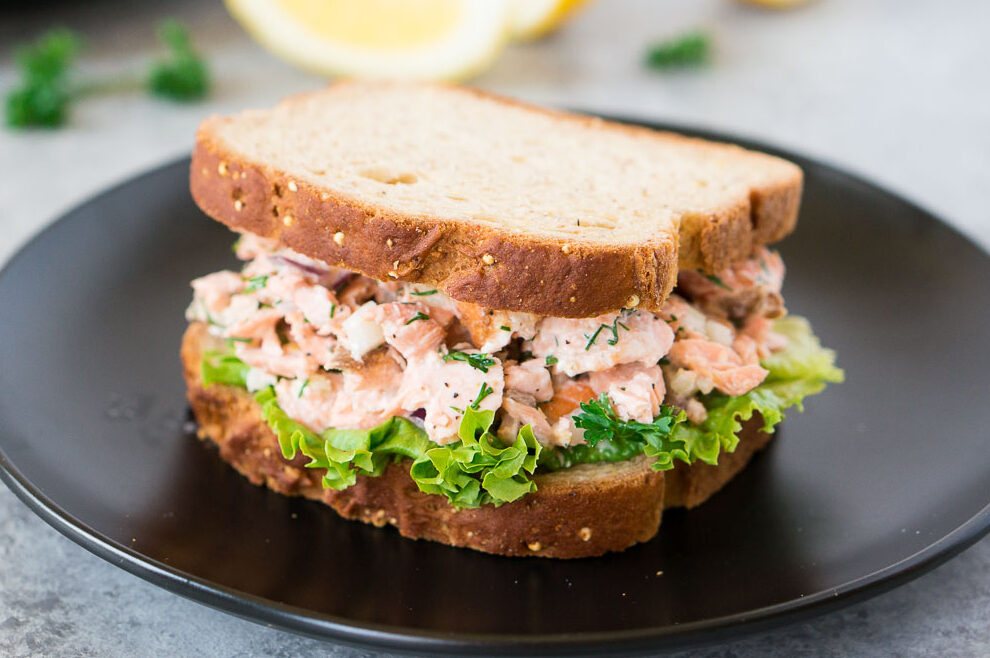 salmon salad sandwich on a black plate