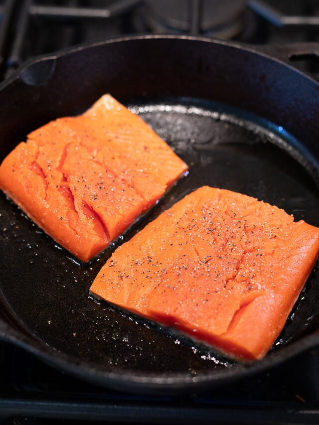 cooking salmon in a skillet on the cooktop