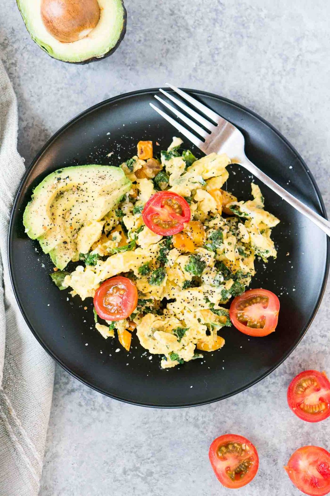 eggs and vegetables breakfast served on a black plate