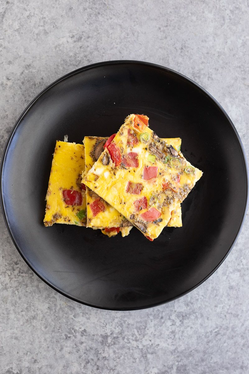 cut eggs and vegetables on a black plate