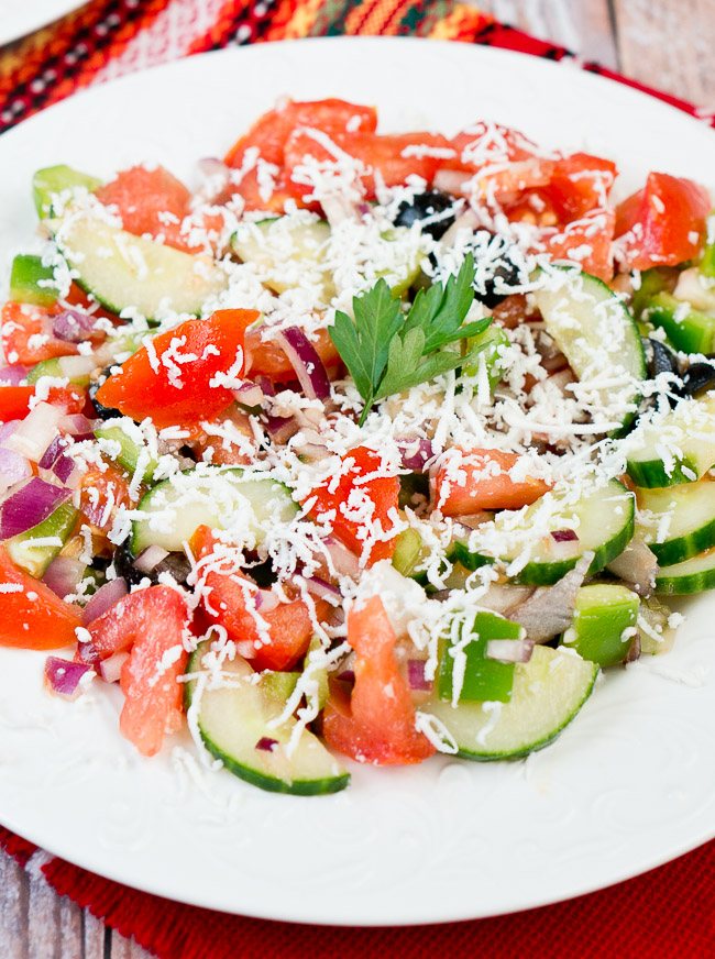 shopska salad garnished with a fresh parsley leaf