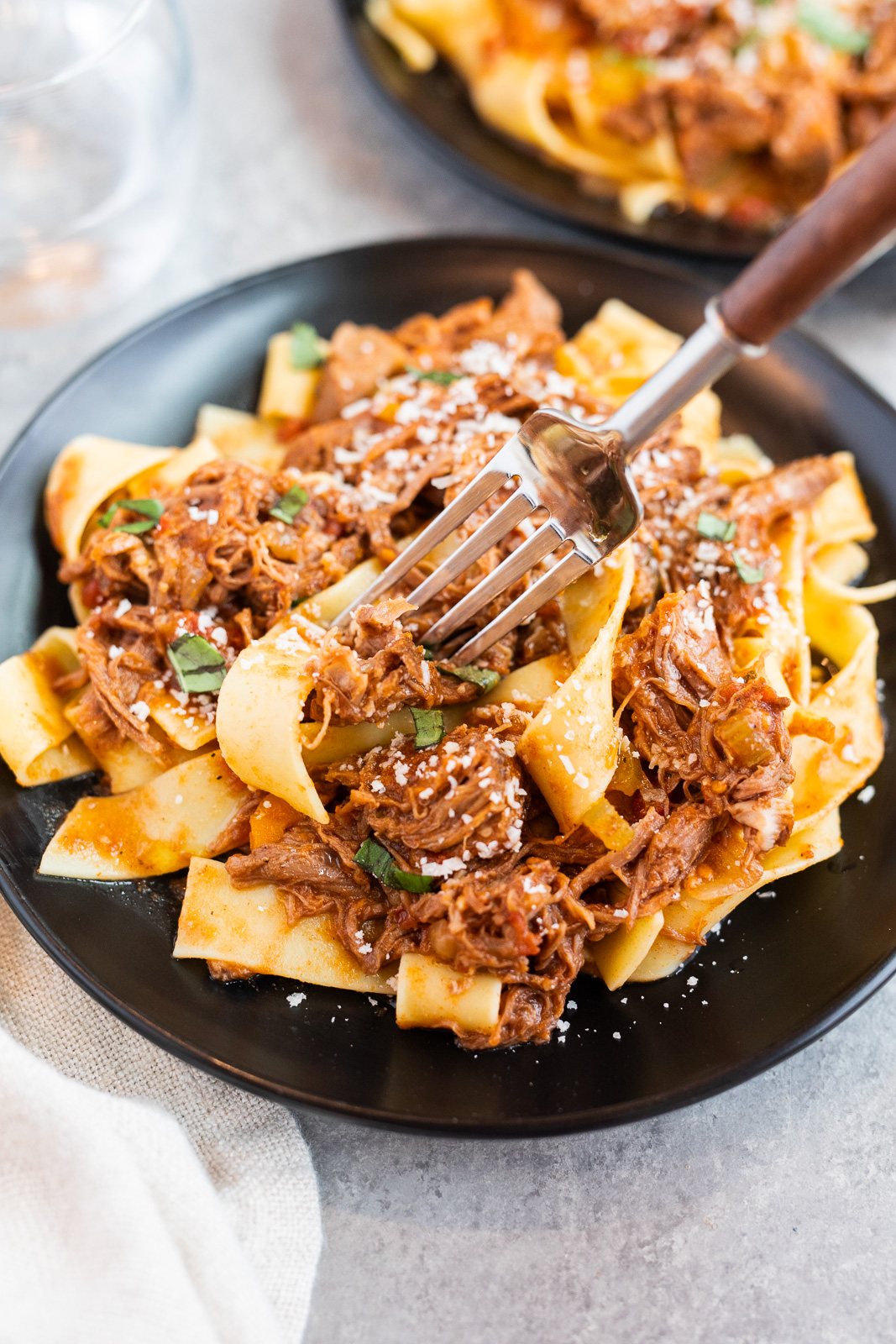 Slow Cooker Beef Ragu served over pappardelle pasta with shredded tender beef, rich tomato sauce, and freshly grated parmesan.