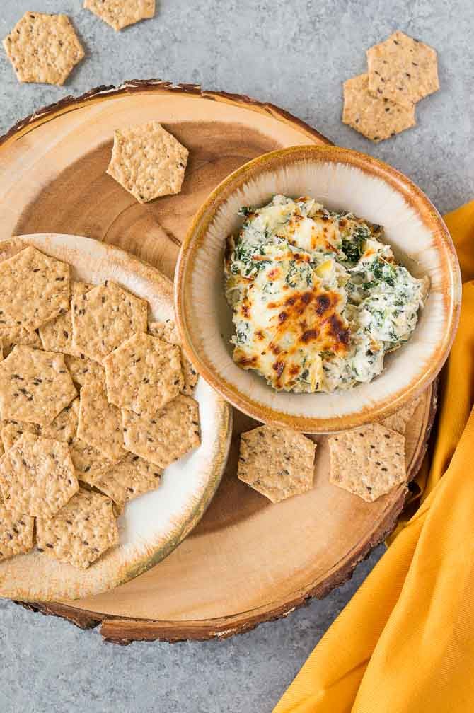 Spinach Artichoke Dip in a bowl on a wooden stand