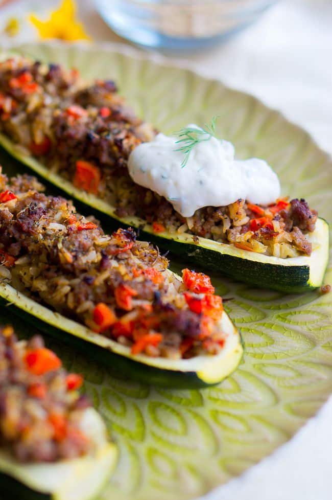 Stuffed Zucchini Boats topped with garlic sauce