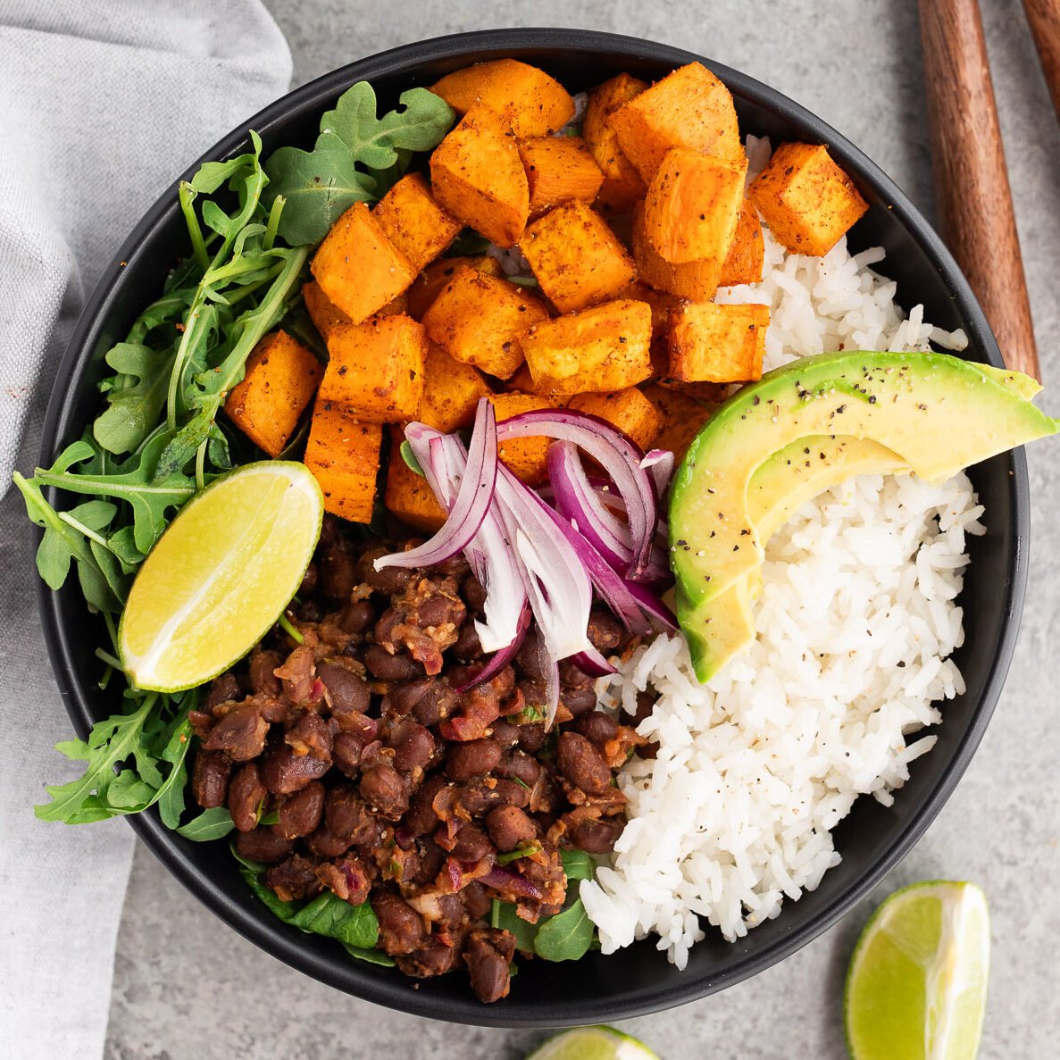 assembling roasted sweet potatoes and black bean bowls