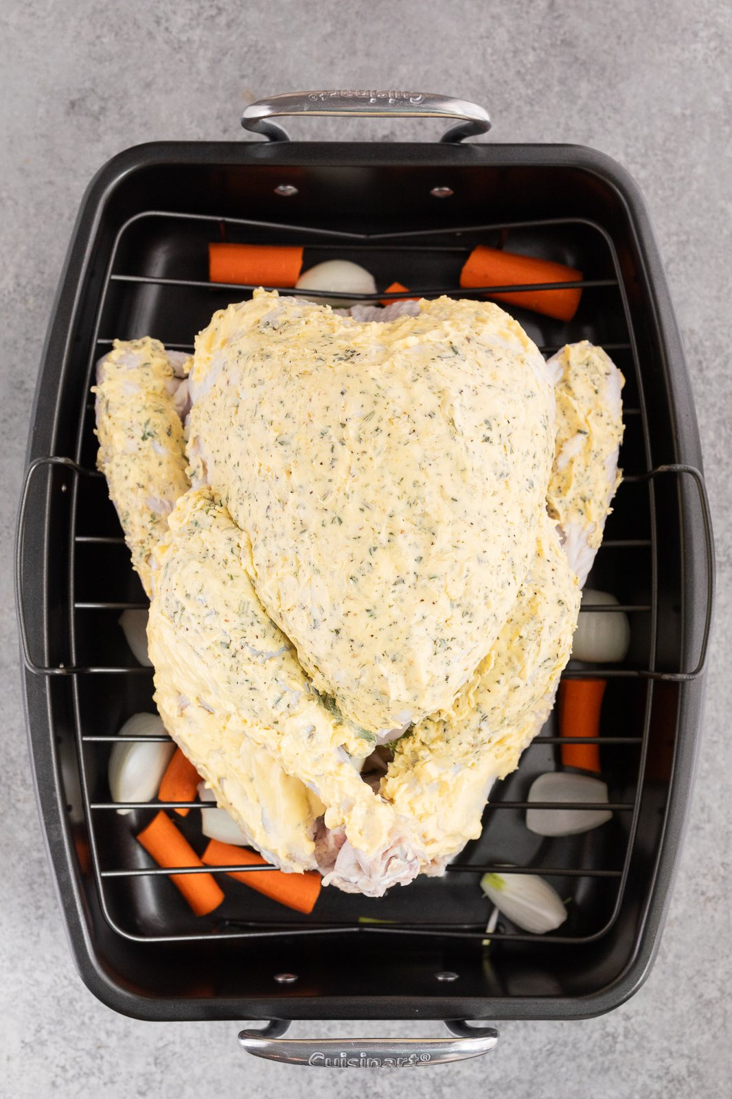 turkey on a roasting rack in a roasting pan