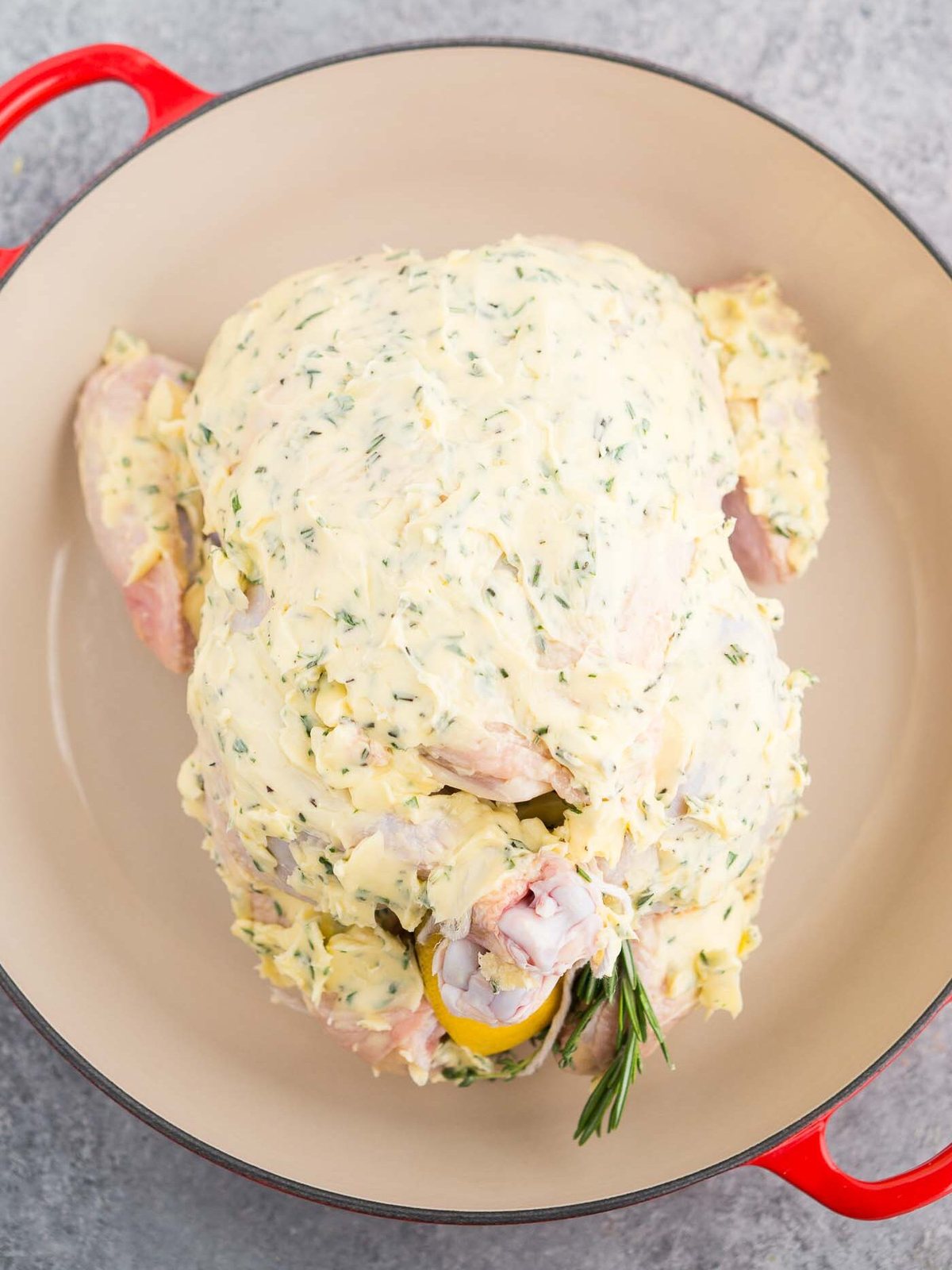 rubbed chicken with herb butter in a roasting pan