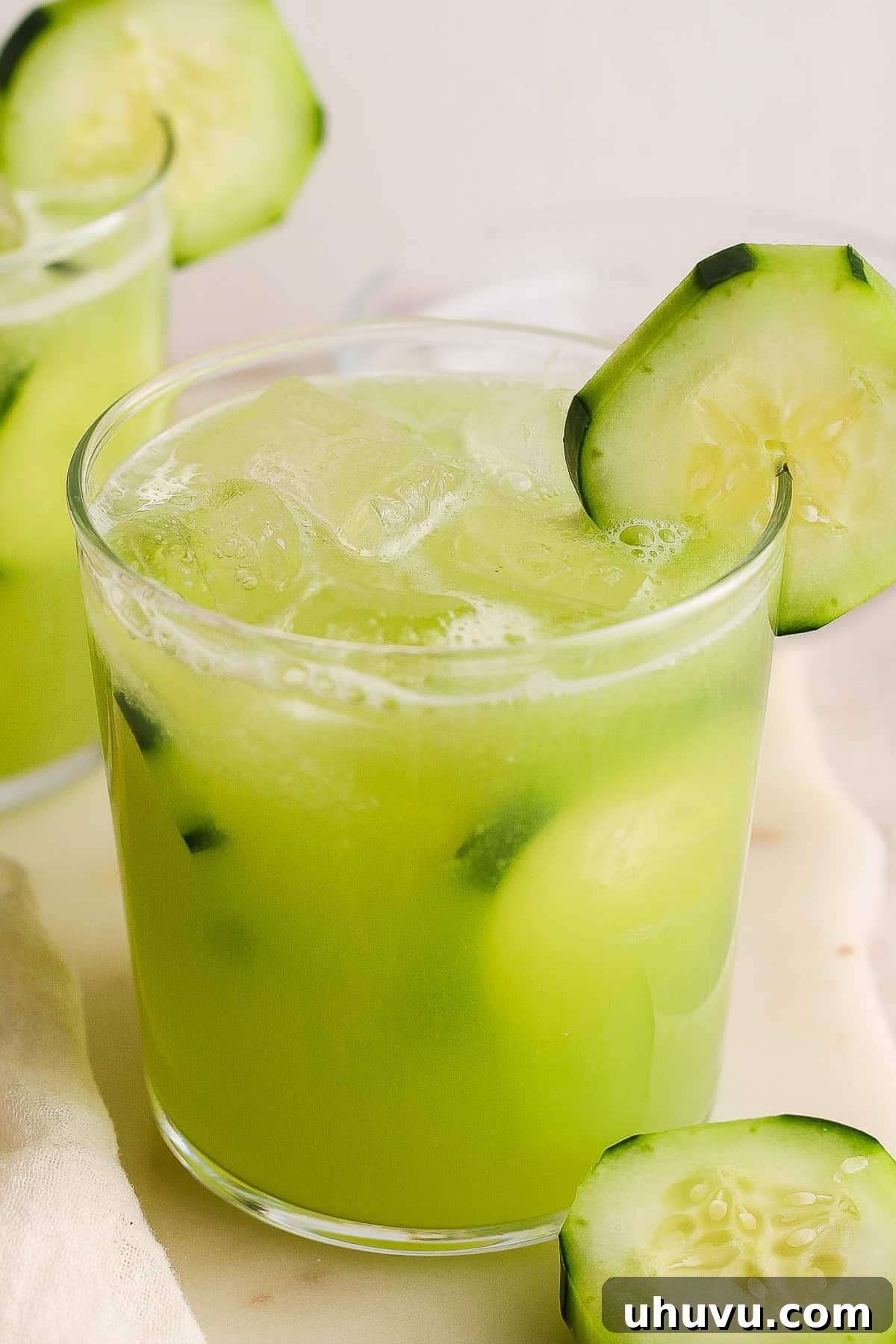 A refreshing glass of iced Agua de Pepino (Mexican Cucumber Agua Fresca) elegantly garnished with a fresh cucumber slice, highlighting its crisp appeal.