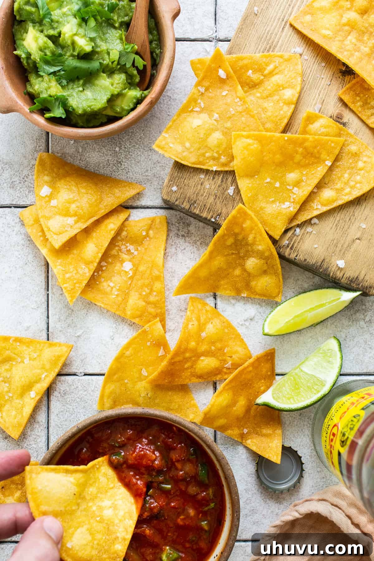 Golden Homemade Tortilla Chips 6 A vibrant spread of homemade tortilla chips served with fresh guacamole and salsa, ready for a feast.