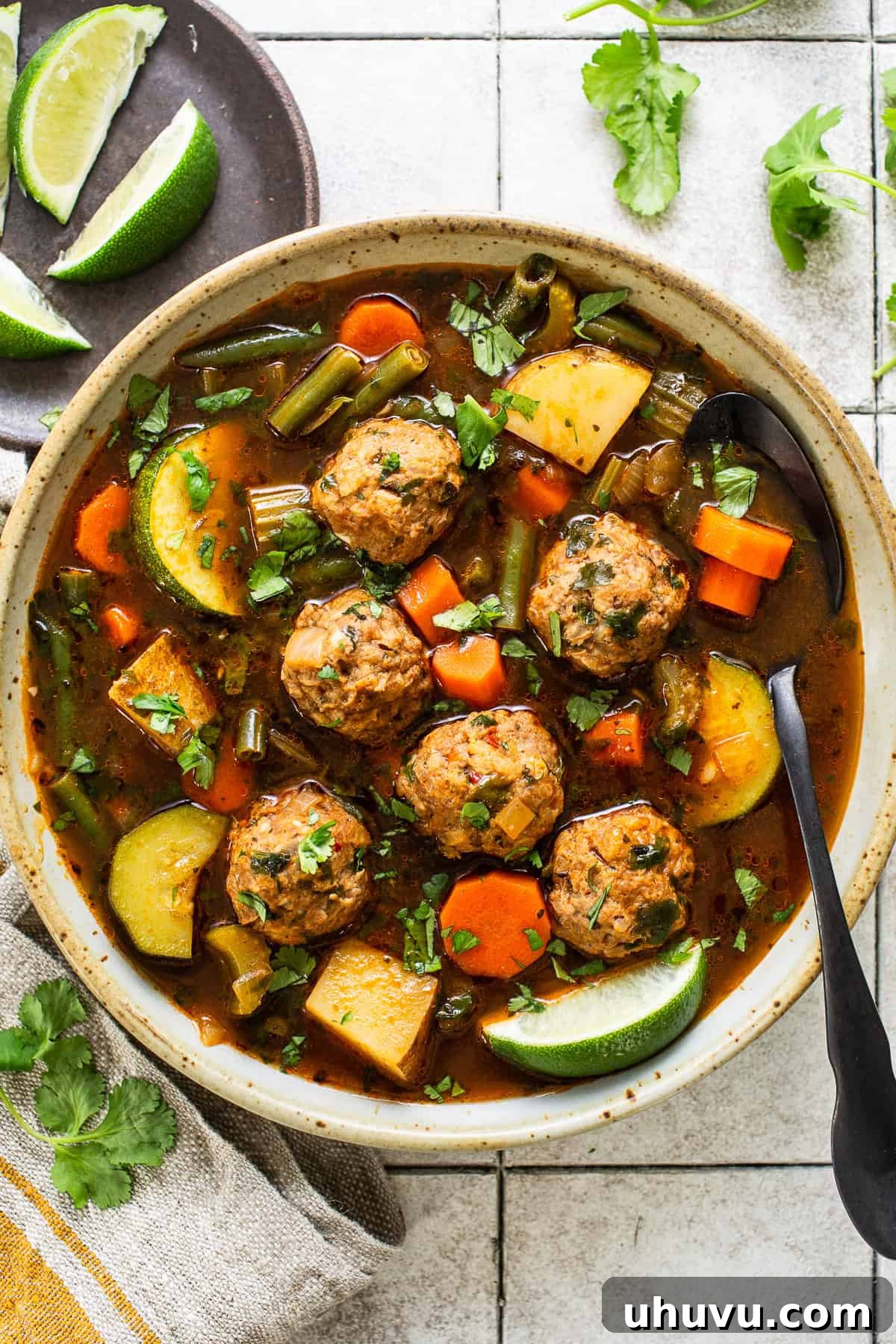 Albondigas soup in a bowl with delicious Mexican meatballs, carrots, zucchini, green beans, and potatoes in a flavorful tomato-based broth.
