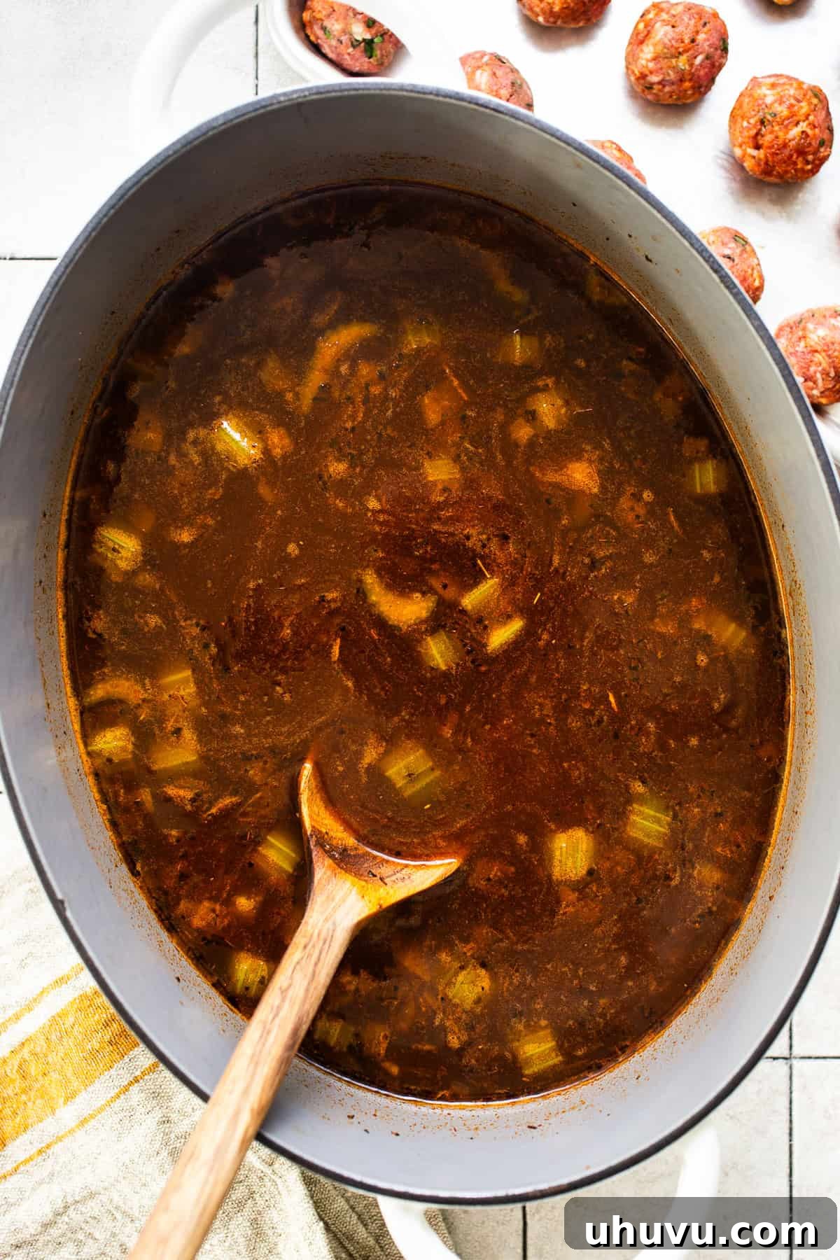 Albondiga soup cooking on the stove in a large Dutch oven.