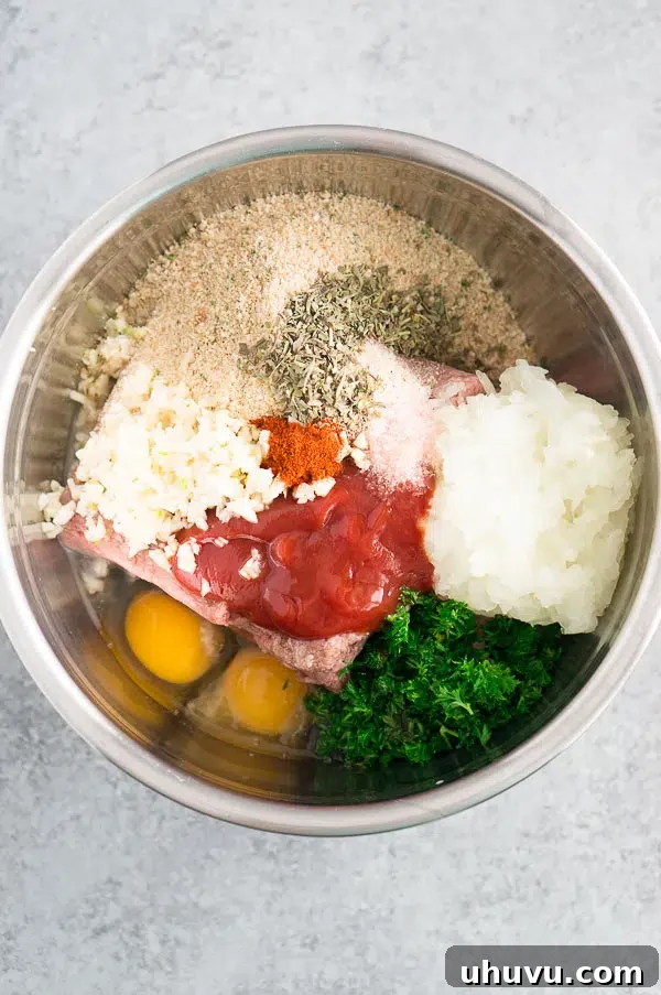 A bowl filled with the uncooked meatloaf ingredients, ready to be mixed for a homemade meal.