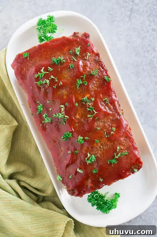 A freshly baked homemade meatloaf, glistening with its delicious glaze, served on a platter, ready to be sliced and enjoyed.
