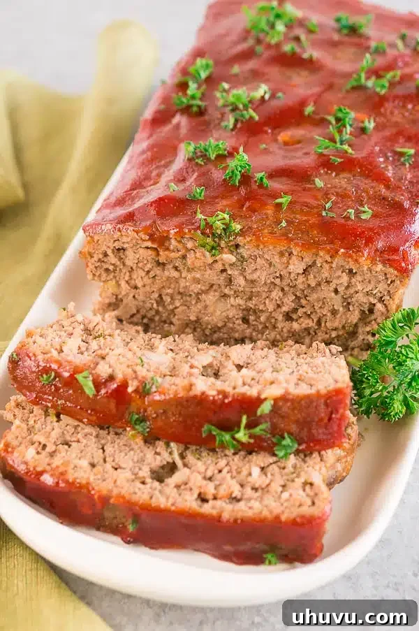 Traditional meatloaf sliced on a serving platter, showing off its perfectly cooked interior and delicious glaze.