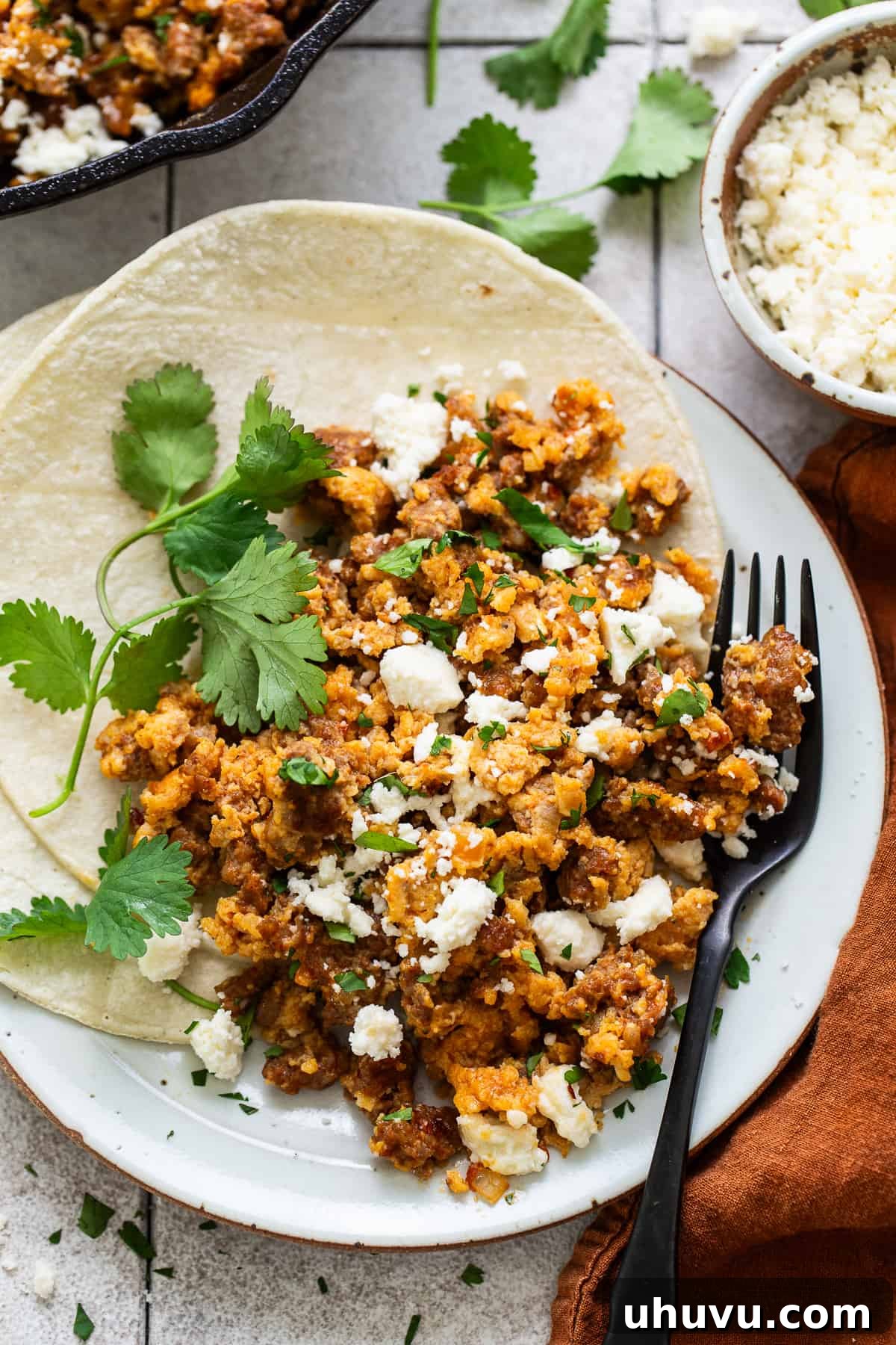 Fiery Chorizo Morning 7 A close-up shot of Chorizo and Eggs served on warm corn tortillas, topped with fresh cilantro and crumbled queso fresco, ready to be devoured.