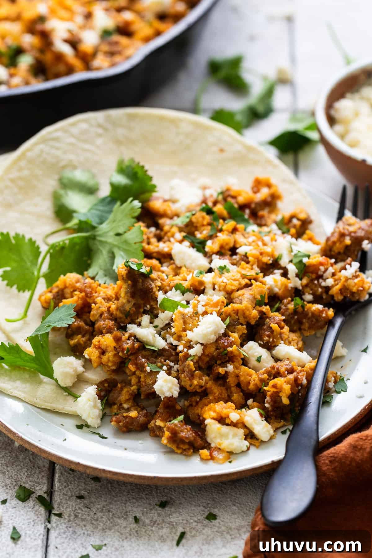 Fiery Chorizo Morning 8 A plate of Chorizo and Eggs artfully plated with a side of warm corn tortillas, showcasing the vibrant colors and appealing texture of the dish.