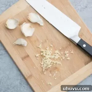 Minced garlic on a cutting board, prepared for use in a recipe