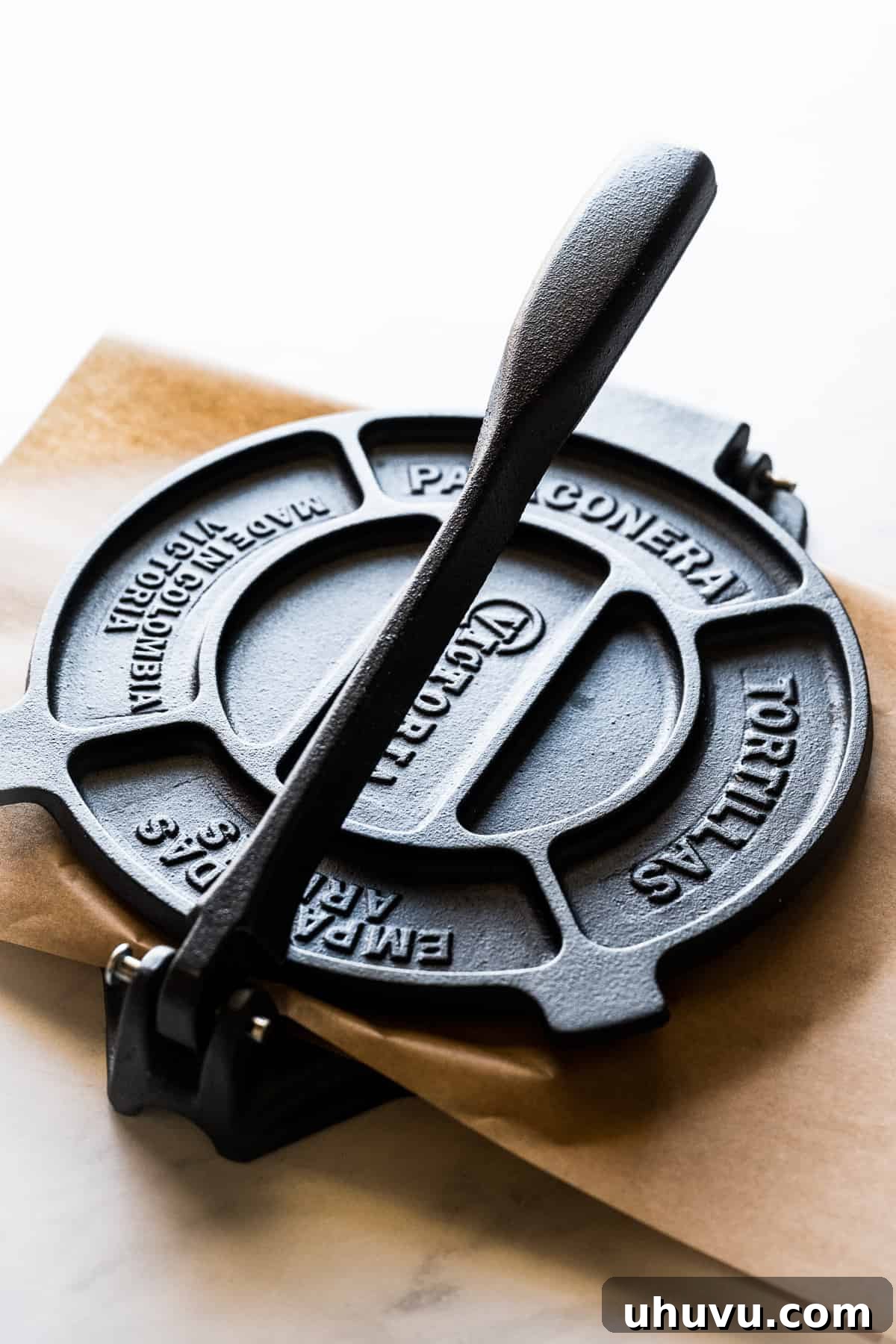 The simple, sturdy design of a tortilla press, essential for making flat, even corn tortillas.