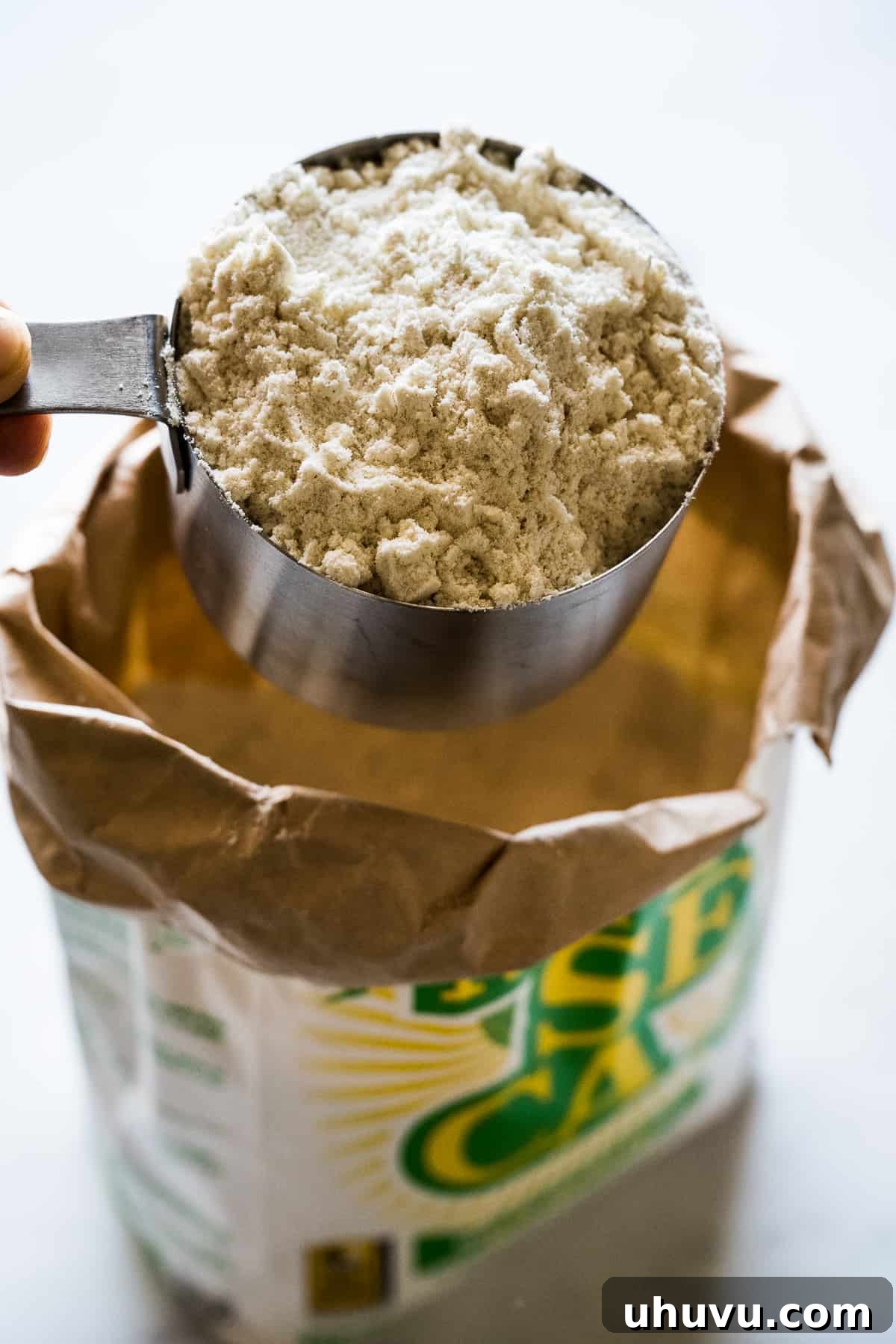Close-up of masa harina in a measuring cup, ready for corn tortilla preparation.