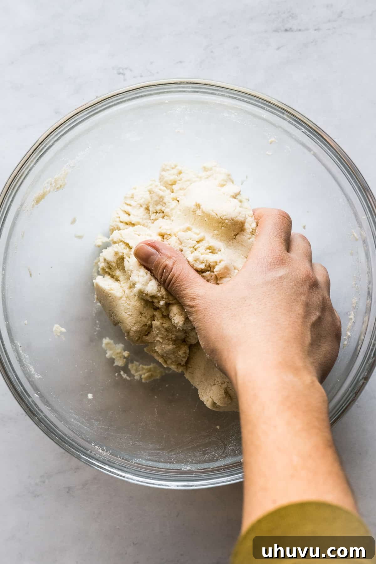 Hands expertly kneading masa harina dough, ensuring perfect consistency for corn tortillas.