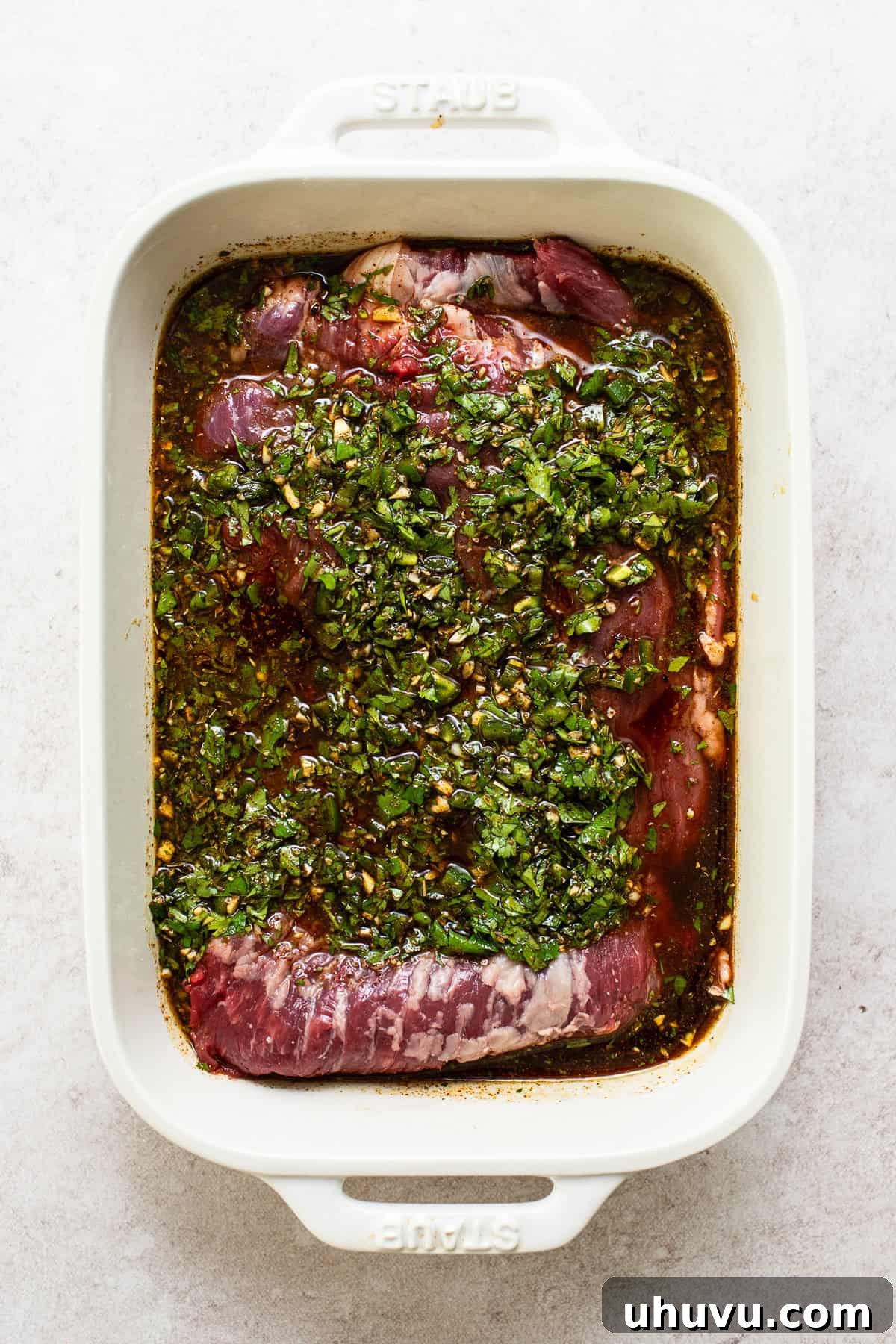 Perfect Grilled Carne Asada 5 Carne asada steak being marinaded in a baking dish.