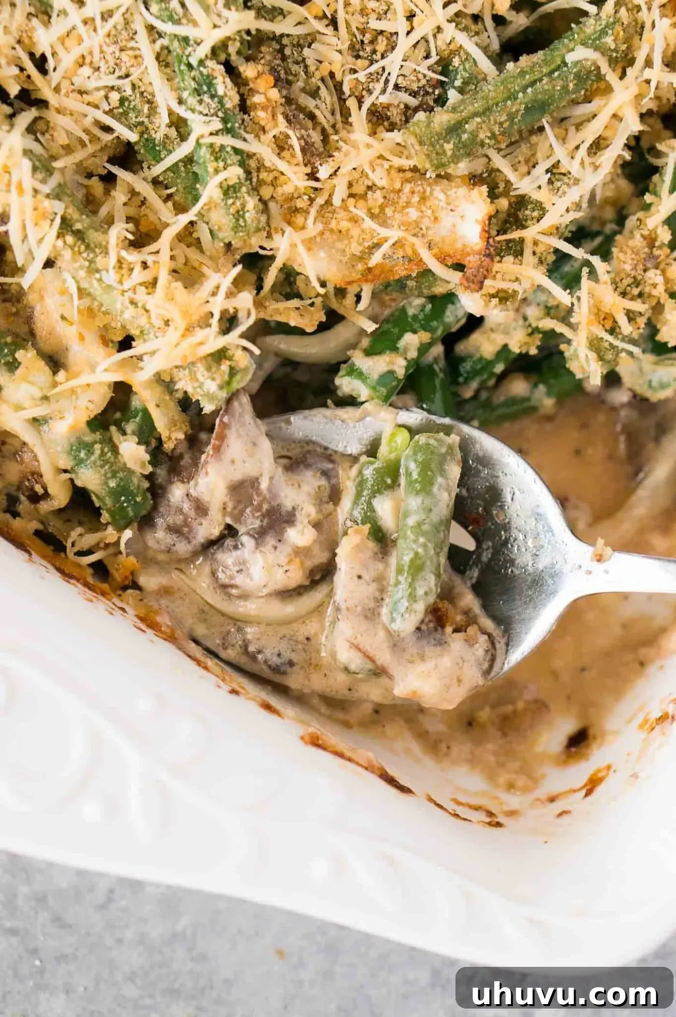 Close-up of a serving of gluten-free green bean casserole on a plate, highlighting its rich texture and topping.