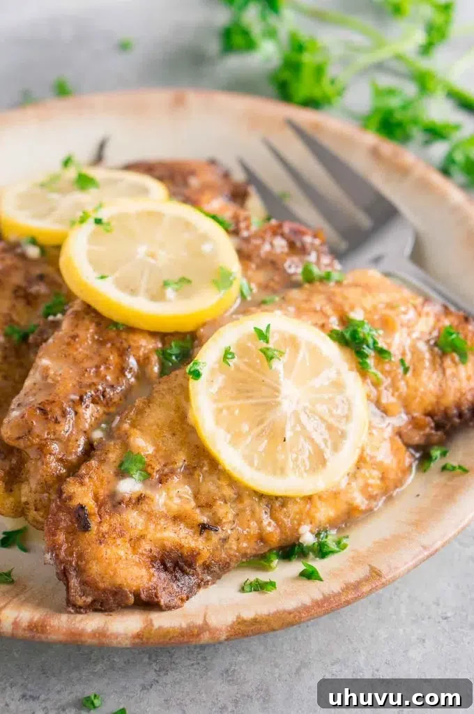 Delicious Chicken Francese Recipe, showcasing golden-brown chicken cutlets coated in a bright lemon butter sauce, garnished with fresh parsley.