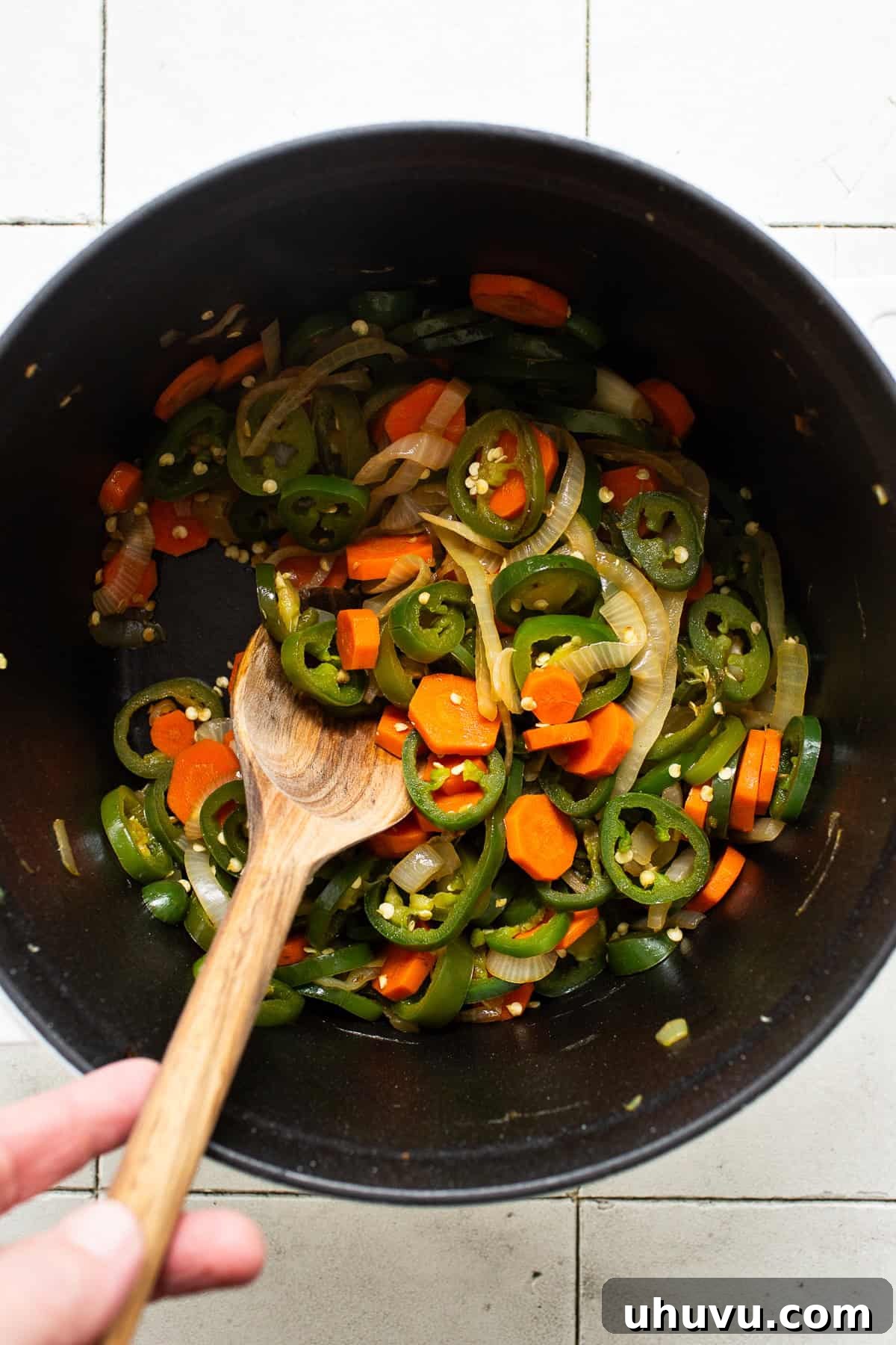 Zesty Pepper Bites 4 Jalapeño peppers, onions, and carrots satueed in a large pot. Vibrant vegetables are sizzling gently in olive oil, beginning to soften and release their aromas.