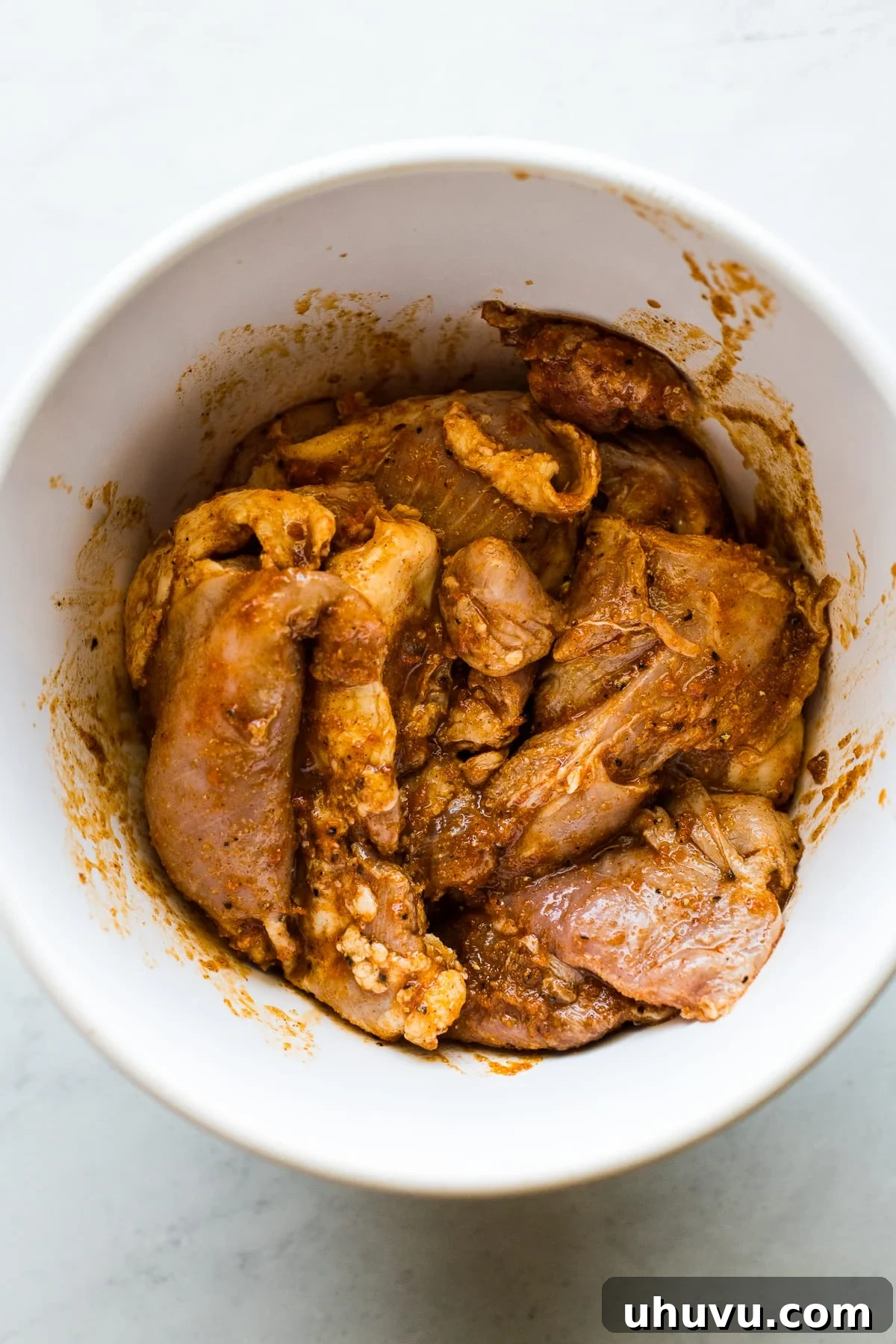 No-Fuss Chicken Tacos 3 Boneless skinless chicken thighs marinating in a bowl with a vibrant blend of spices and fresh lime juice.