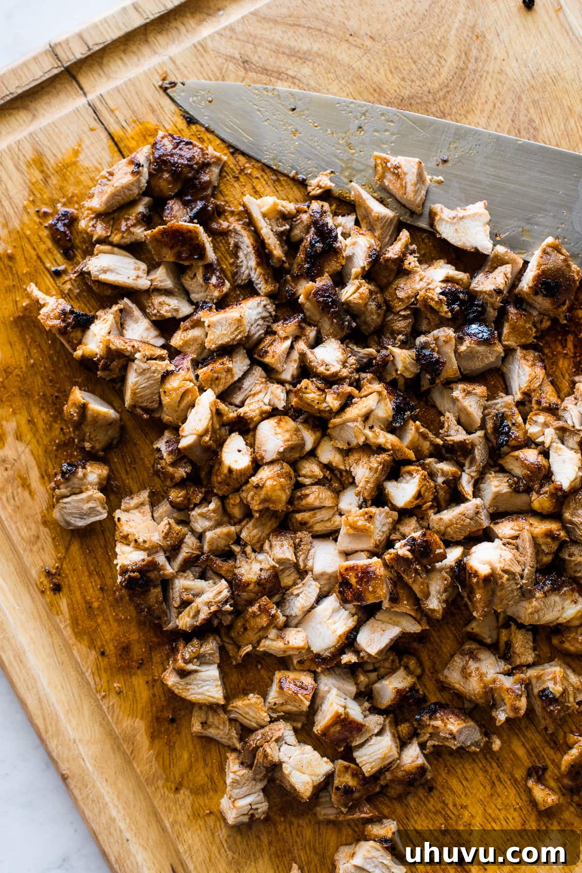 No-Fuss Chicken Tacos 4 Juicy and tender diced chicken on a wooden cutting board, ready for taco assembly.