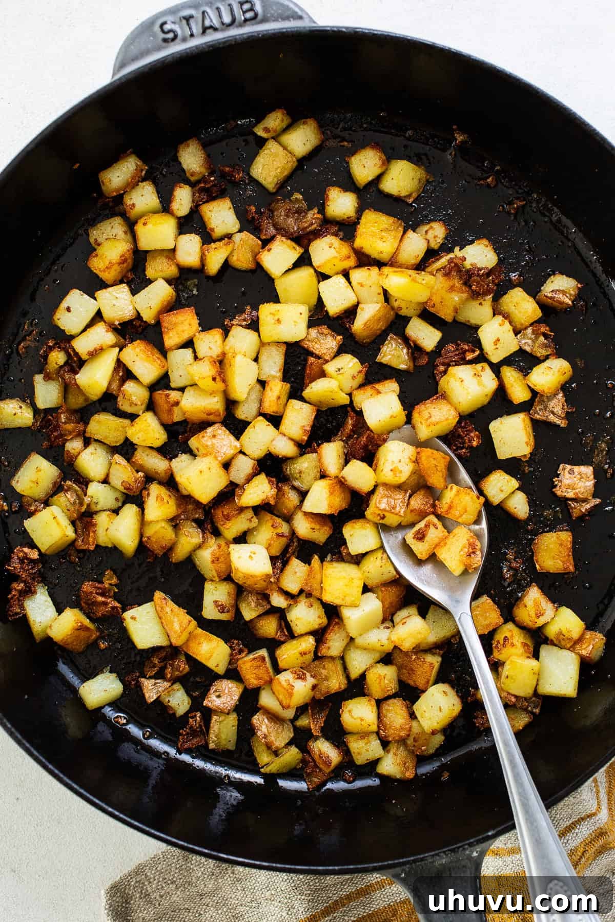 Morning Taco Bliss 4 Diced potatoes and chorizo cooking in a large skillet with olive oil, creating a rich, aromatic blend.