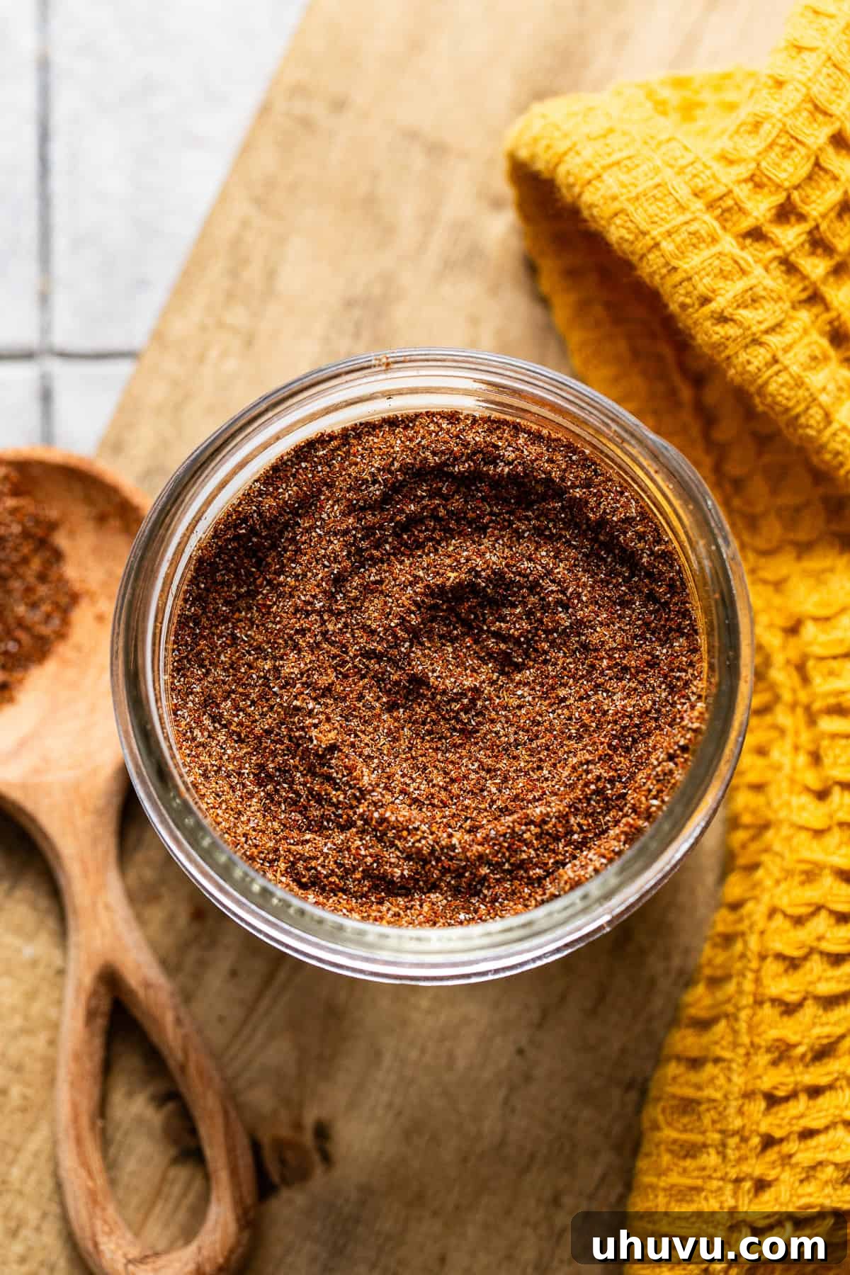 A glass jar filled with vibrant homemade taco seasoning, ready for storage and use.
