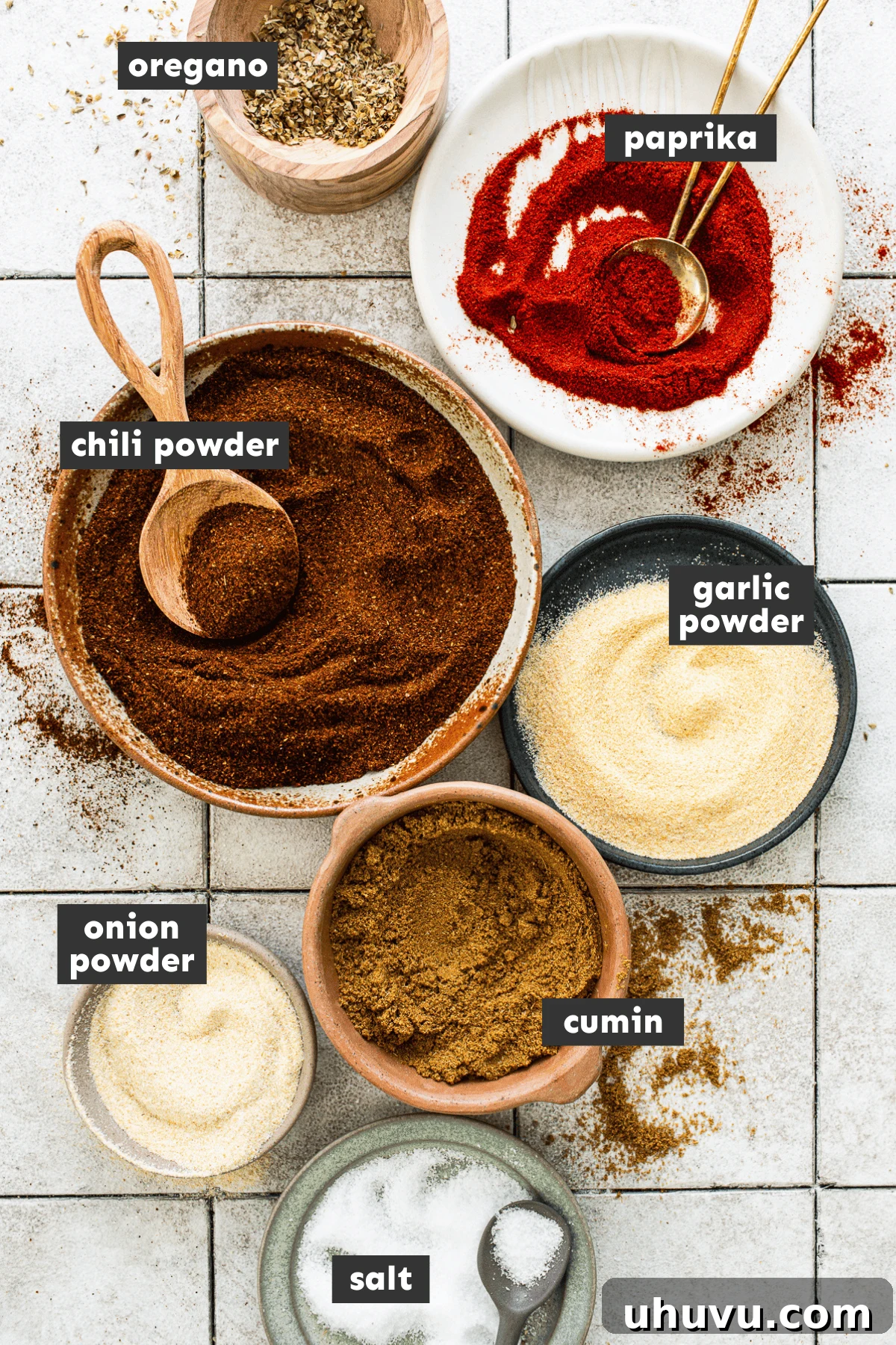 Individual ingredients for homemade taco seasoning, neatly measured in small mixing bowls.