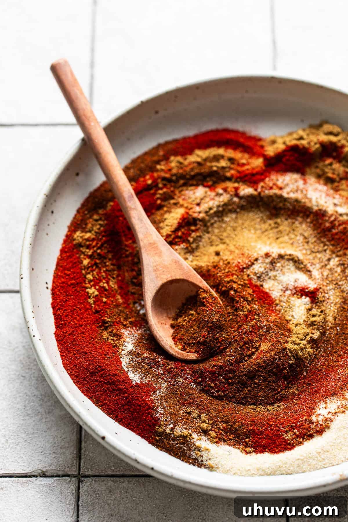 All seven taco seasoning spices poured into a large mixing bowl, ready to be combined.